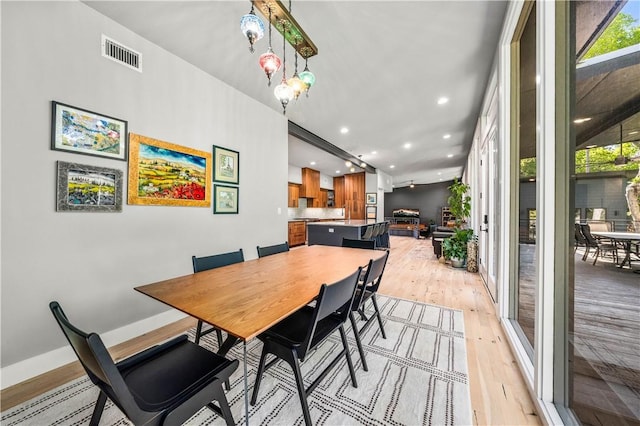 dining room featuring light wood-type flooring and an inviting chandelier