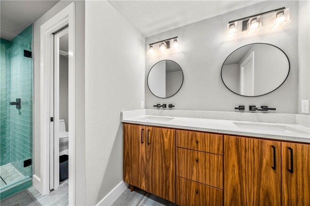 bathroom featuring vanity, toilet, and a shower with shower door