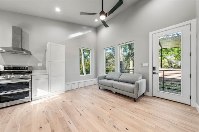 interior space with light wood-type flooring, high vaulted ceiling, and ceiling fan