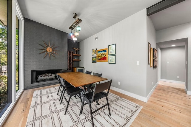 dining area with a fireplace and light hardwood / wood-style flooring