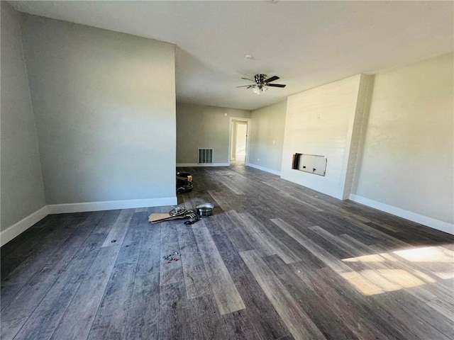 unfurnished living room featuring ceiling fan and dark hardwood / wood-style flooring