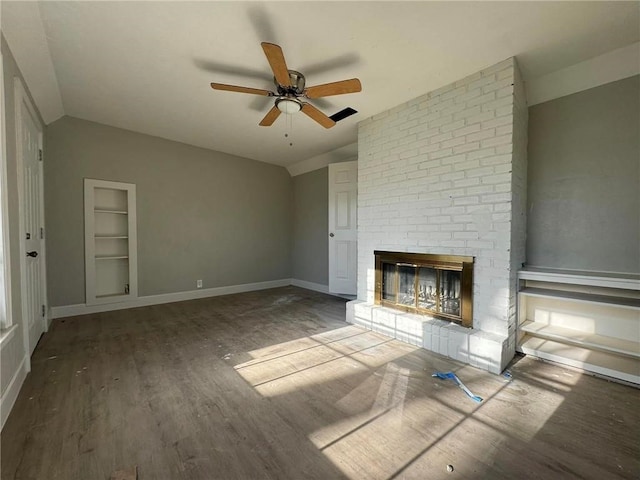 unfurnished living room featuring wood-type flooring, a brick fireplace, ceiling fan, and lofted ceiling