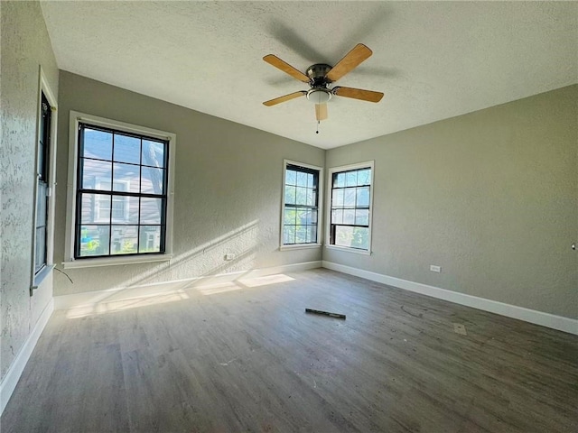 unfurnished room featuring dark hardwood / wood-style floors, ceiling fan, and a textured ceiling