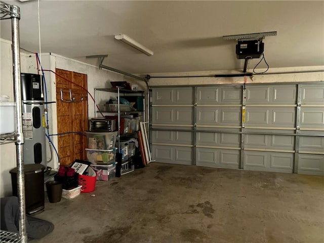 garage featuring heat pump water heater and a garage door opener