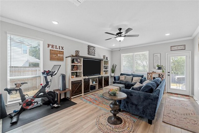 living room featuring a wealth of natural light, light hardwood / wood-style floors, and ornamental molding