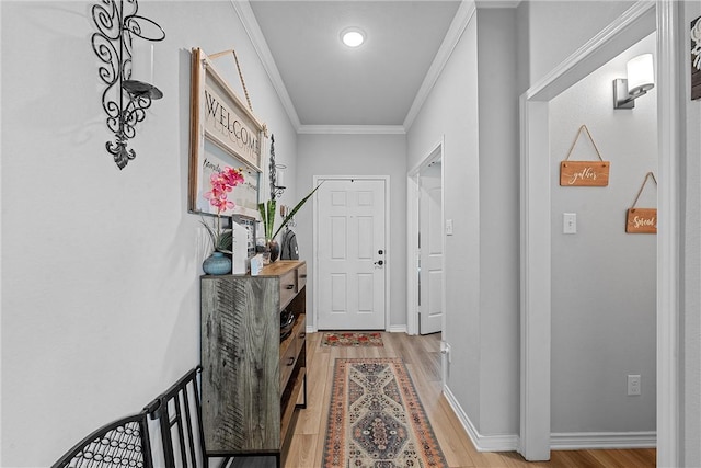 hall with ornamental molding and light hardwood / wood-style flooring