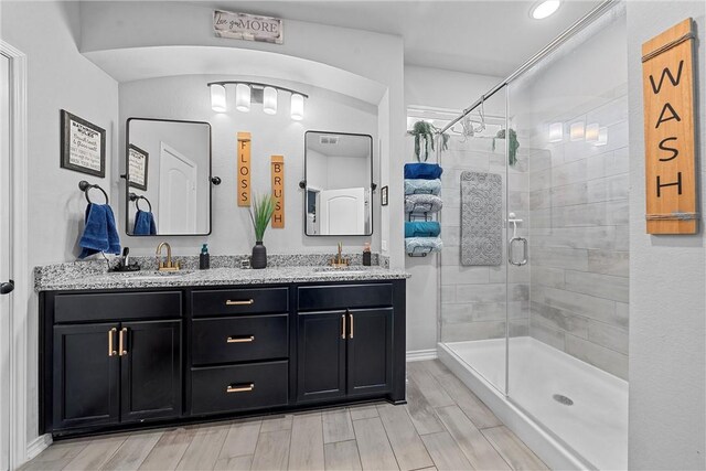 bathroom featuring hardwood / wood-style floors, vanity, and an enclosed shower