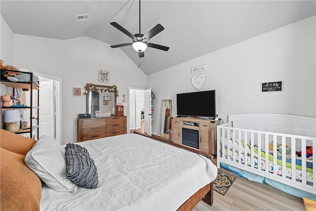 bedroom featuring ceiling fan, light hardwood / wood-style flooring, and lofted ceiling