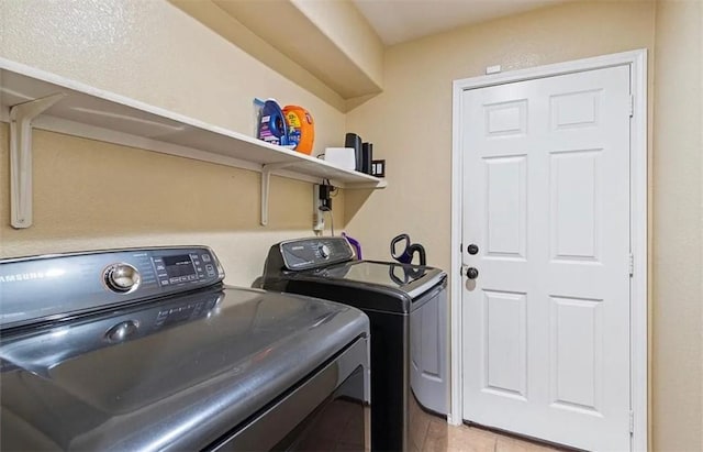 laundry area featuring light tile patterned floors and washing machine and clothes dryer