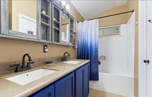 bathroom featuring shower / tub combo with curtain, vanity, vaulted ceiling, and tile patterned floors