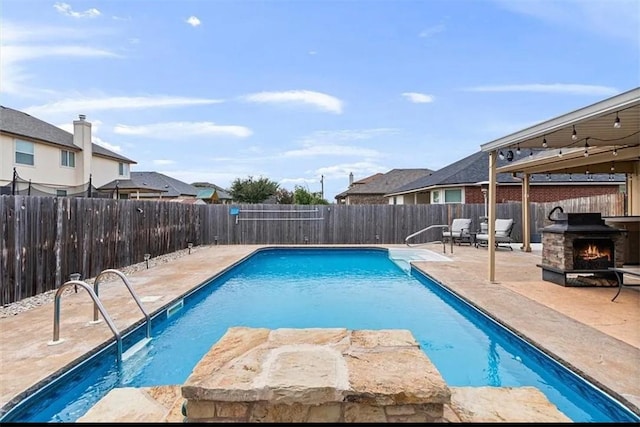 view of swimming pool featuring a patio and a fire pit