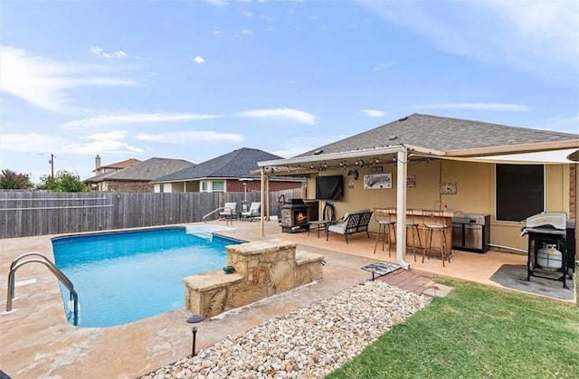 view of pool featuring a patio area, grilling area, and a bar