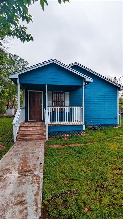 view of front facade featuring covered porch and a front lawn