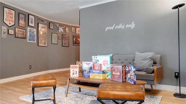 sitting room with ornamental molding and hardwood / wood-style floors