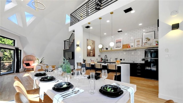 dining area featuring a high ceiling and light wood-type flooring