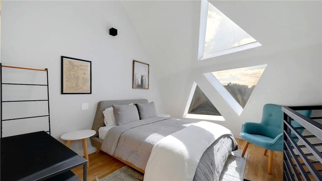 bedroom featuring a towering ceiling and hardwood / wood-style floors