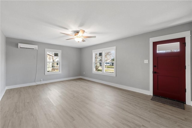 entrance foyer with a wall mounted AC, ceiling fan, and light hardwood / wood-style floors