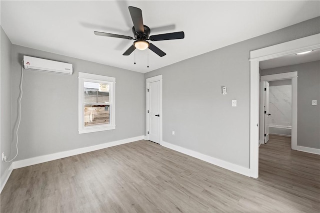 unfurnished room with ceiling fan, wood-type flooring, and a wall mounted AC