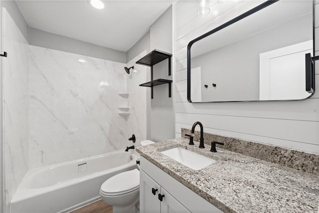 full bathroom with tub / shower combination, wood walls, hardwood / wood-style floors, toilet, and vanity