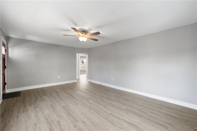 spare room with a wealth of natural light, ceiling fan, and light hardwood / wood-style flooring