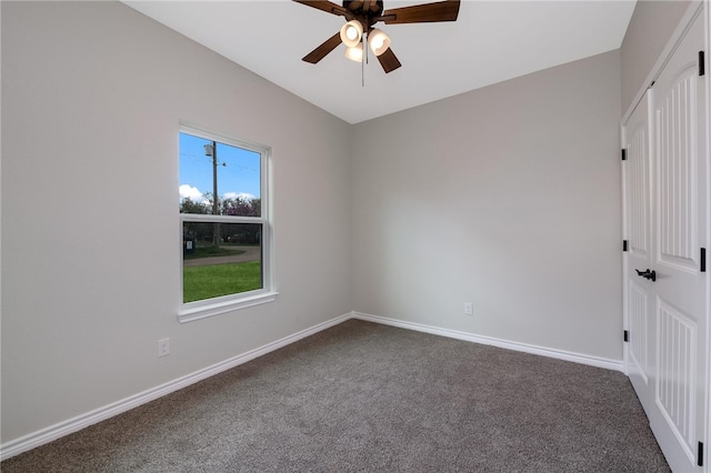 spare room with dark colored carpet and ceiling fan