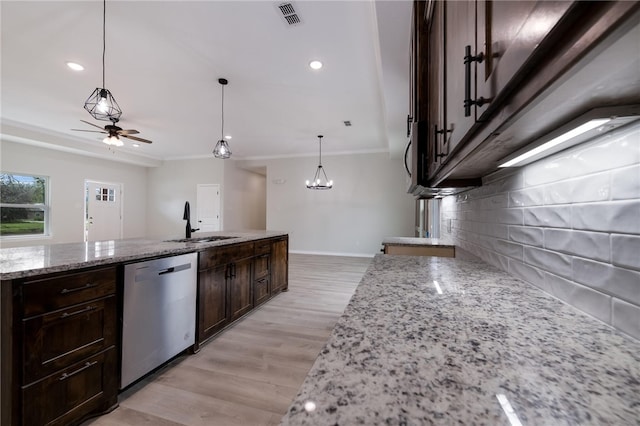 kitchen featuring backsplash, light stone counters, pendant lighting, and stainless steel dishwasher