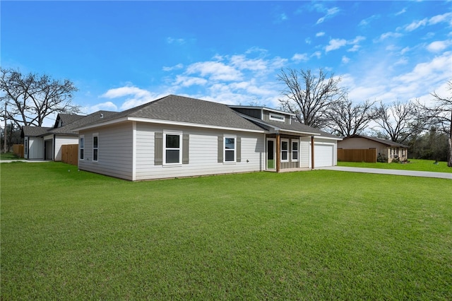 view of front of home with a front lawn, an attached garage, driveway, and a shingled roof