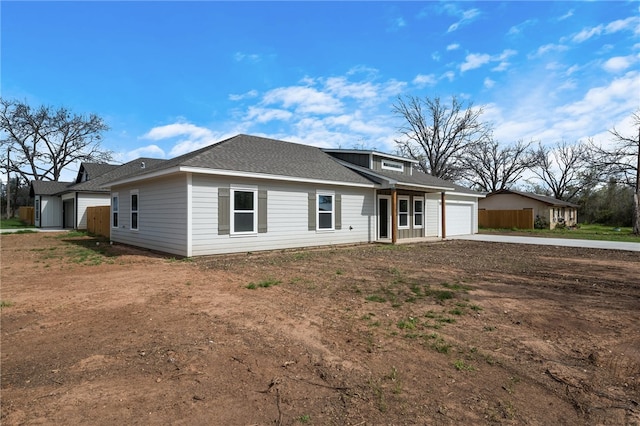 view of front of home featuring concrete driveway, an attached garage, and a shingled roof