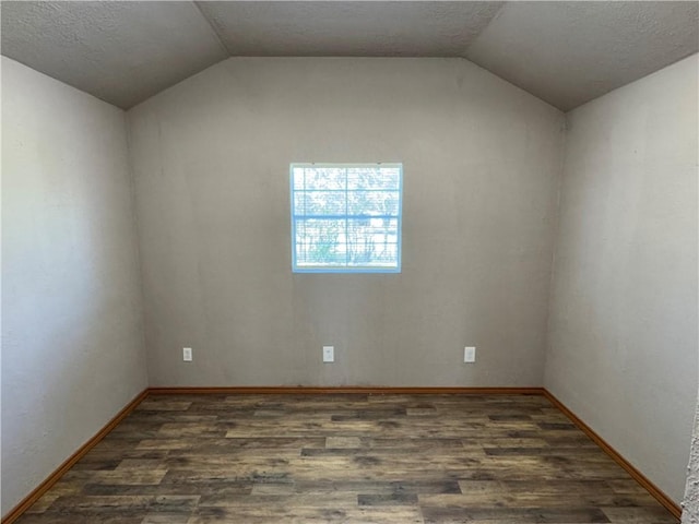 unfurnished room with lofted ceiling and dark wood-type flooring