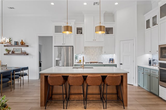 kitchen featuring white cabinetry, stainless steel appliances, and a kitchen island with sink