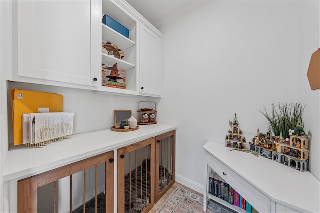 bar with white cabinets and ornamental molding