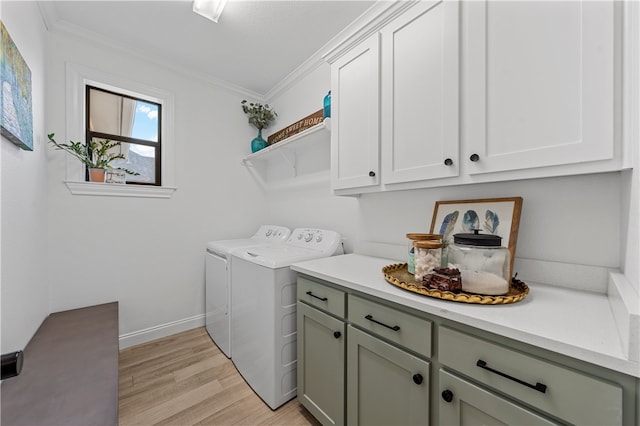 washroom with cabinets, light hardwood / wood-style floors, crown molding, and washing machine and clothes dryer