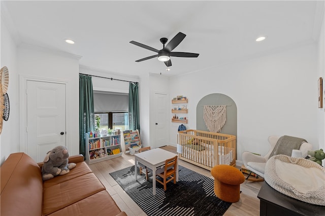 interior space with ceiling fan, crown molding, and light hardwood / wood-style flooring