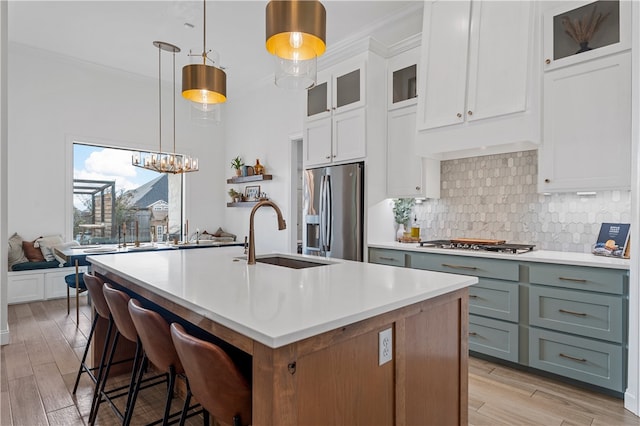 kitchen with white cabinets, pendant lighting, sink, and stainless steel appliances