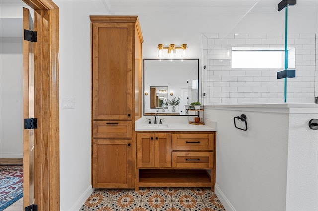 bathroom with a tile shower, vanity, and ornamental molding