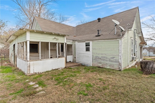 rear view of house with a yard and a sunroom