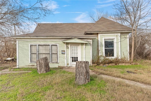 bungalow-style home with a front yard