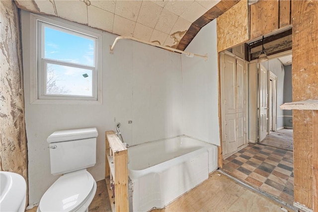 bathroom featuring a tub and toilet