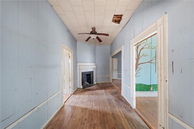 unfurnished living room with wood-type flooring and ceiling fan