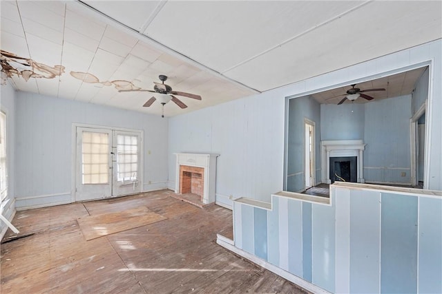 unfurnished living room featuring hardwood / wood-style flooring, ceiling fan, and french doors