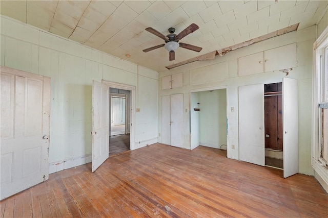 unfurnished bedroom featuring ceiling fan, brick ceiling, and wood-type flooring