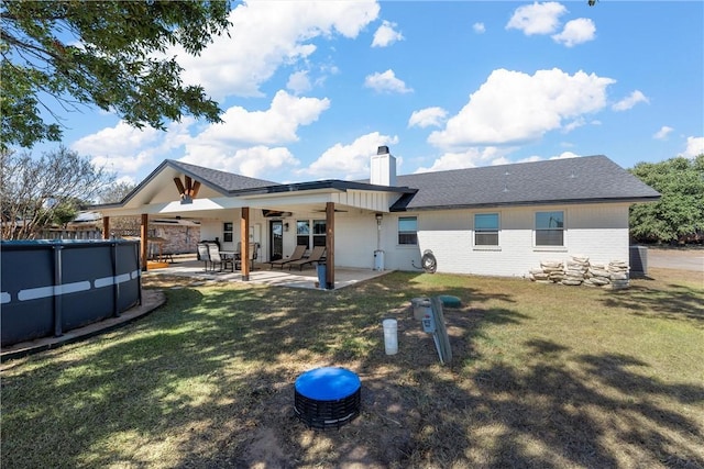 rear view of house with a patio area, ceiling fan, and a yard