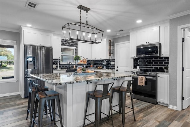 kitchen featuring appliances with stainless steel finishes, dark hardwood / wood-style floors, and white cabinetry