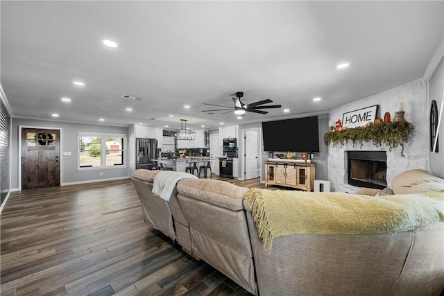 living room with crown molding, ceiling fan, and dark wood-type flooring