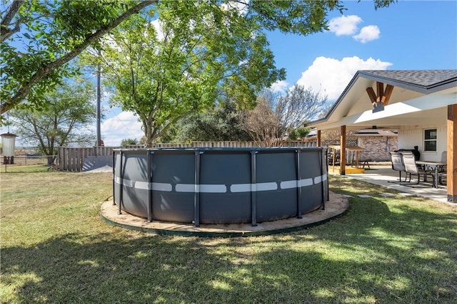 view of swimming pool featuring ceiling fan, a patio area, and a lawn