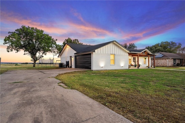 modern farmhouse style home featuring a lawn and a garage