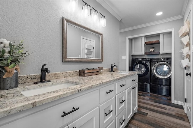 clothes washing area featuring cabinets, dark hardwood / wood-style flooring, sink, and washing machine and clothes dryer