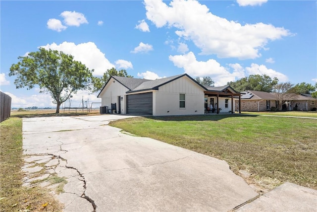 view of front of property featuring a front lawn, central AC unit, and a garage