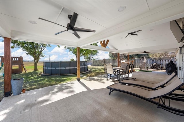 view of patio featuring a playground, a pool, and ceiling fan