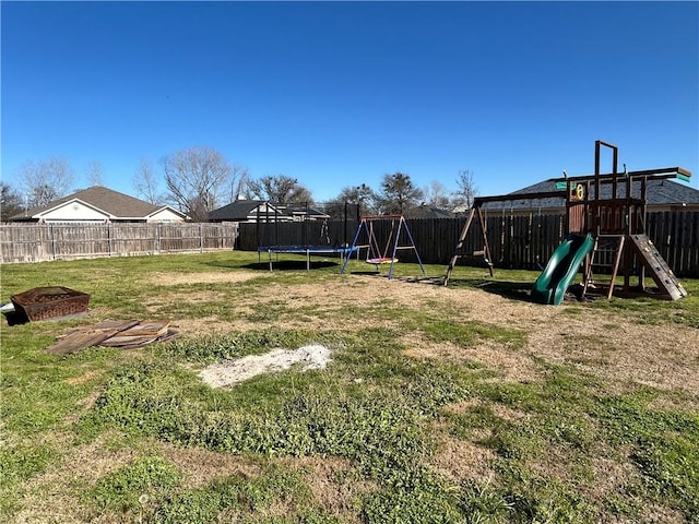 view of yard featuring a fenced backyard, a trampoline, and a playground